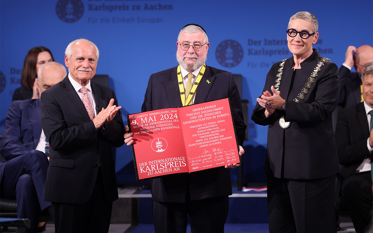Für seinen Einsatz für Toleranz, Pluralismus, Verständigung und den interreligiösen Dialog erhielt der Präsident der Konferenz der europäischen Rabbiner, Oberrabbiner Pinchas Goldschmidt, Anfang Mai in Aachen den Karlspreis. Der Preis geht ebenfalls an die jüdischen Gemeinschaften in Europa. Der Internationale Karlspreis zu Aachen gilt als eine der höchsten europäischen Auszeichnungen. Die deutschen Volksbanken und Raiffeisenbanken sind dem Karlspreis seit vielen Jahren als Förderer verbunden. Im Bild: Pinchas Goldschmidt (Mitte), Aachens Bürgermeisterin Sibylle Keupen und Dr. Jürgen Linden, Vorsitzender des Karlspreisdirektoriums (links).