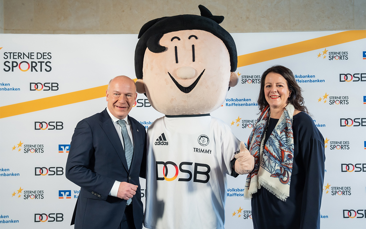Preisverleihung der Sterne des Sports: BVR-Vorständin Tanja Müller-Ziegler mit Berlins Regierendem Bürgermeister Kai Wegner und dem Maskottchen des Deutschen Olympischen Sportbundes Trimmy.